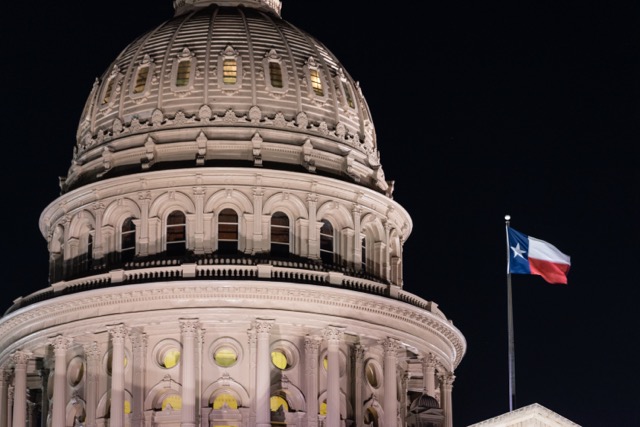 Texas Capital Building at night with flag flying